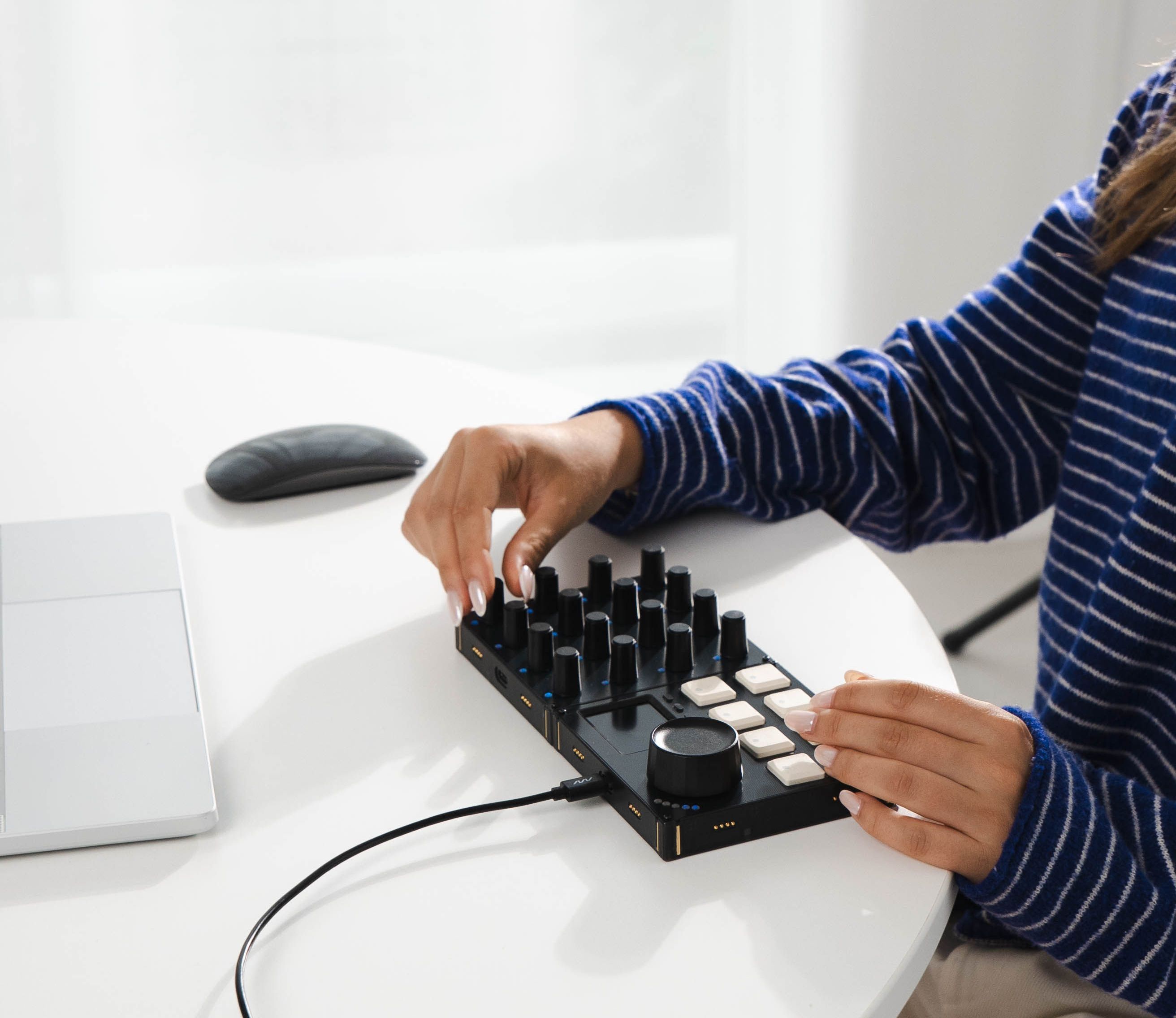 Woman turning knobs on a MIDI controller.
